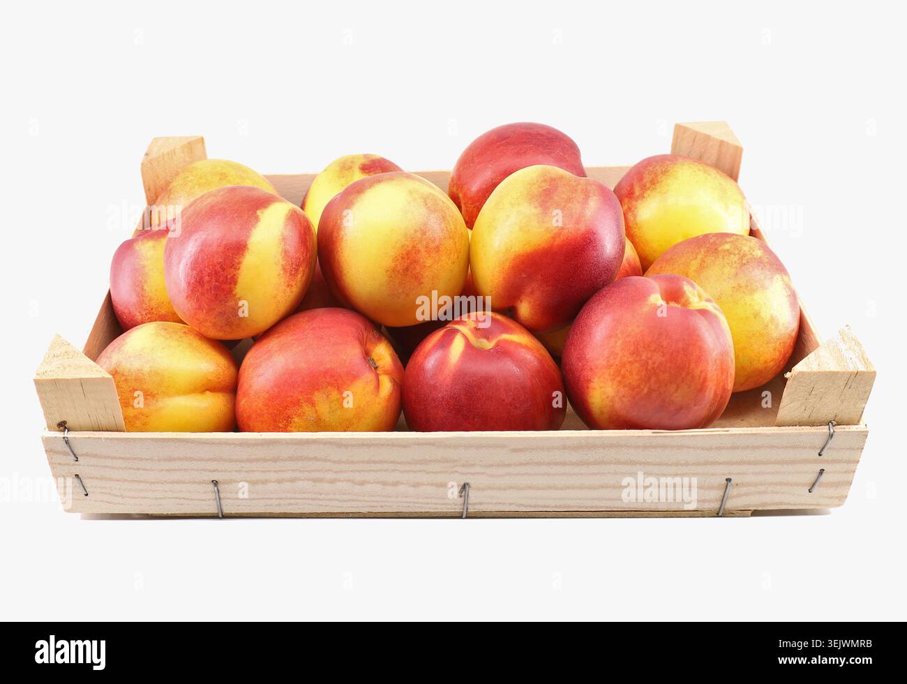 Holzkiste voller Nektarine-Pfirsiche auf weißem Hintergrund. Stockfoto