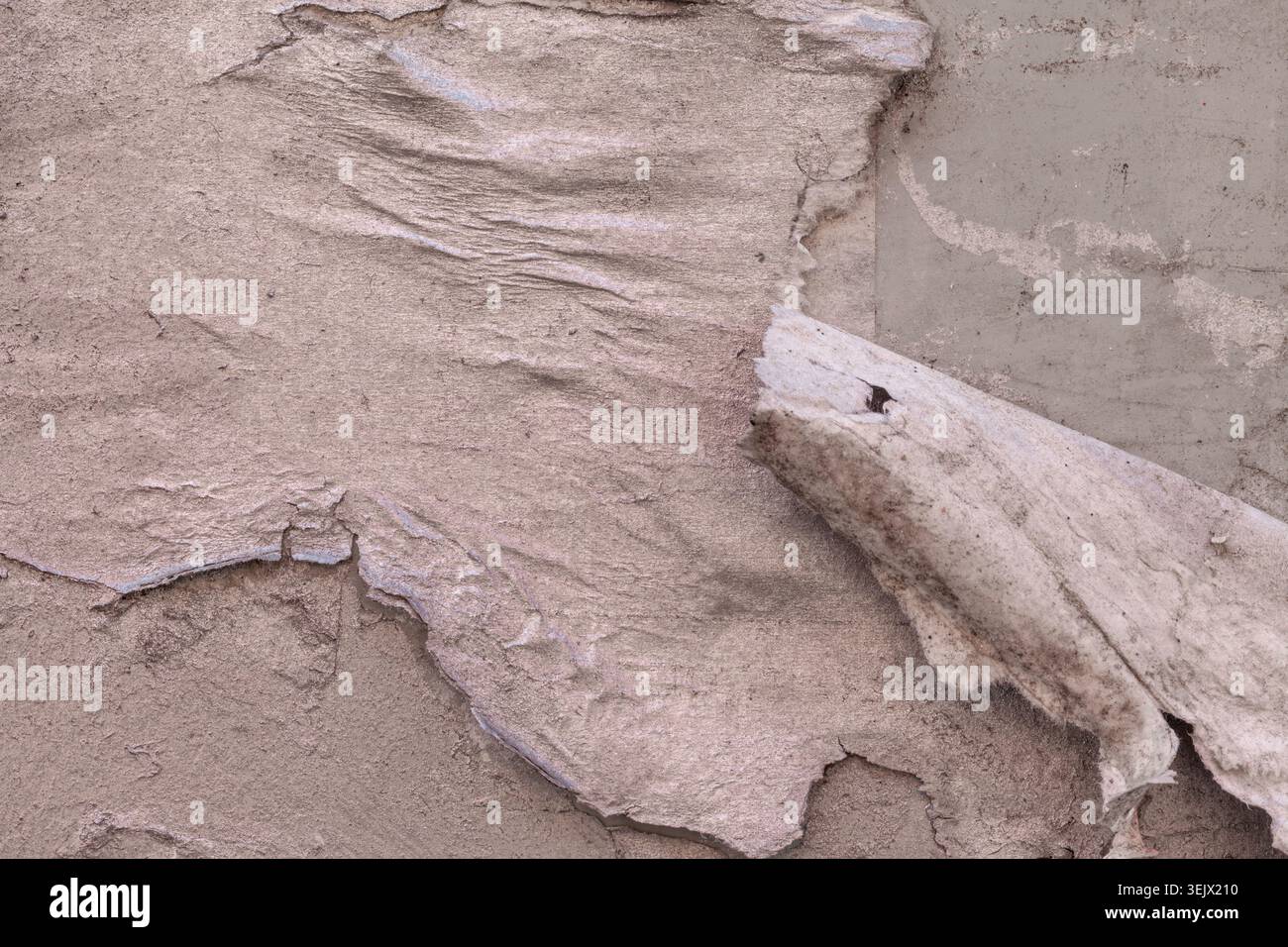 Metalloberfläche mit gestickten und verdorbenen Papierschichten, überstrichen mit silberfarbener Hintergrundstruktur Stockfoto