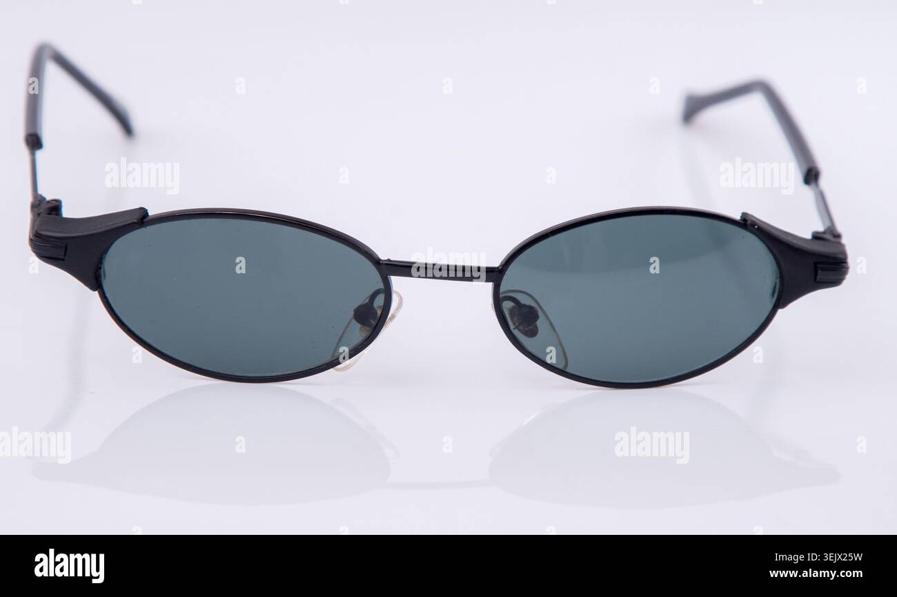 Schwarze Vintage Sonnenbrille mit schlankem Metallrahmen. Klassische Retro-Brille mit dunklem Mini-Objektiv auf weißem Hintergrund. Stockfoto