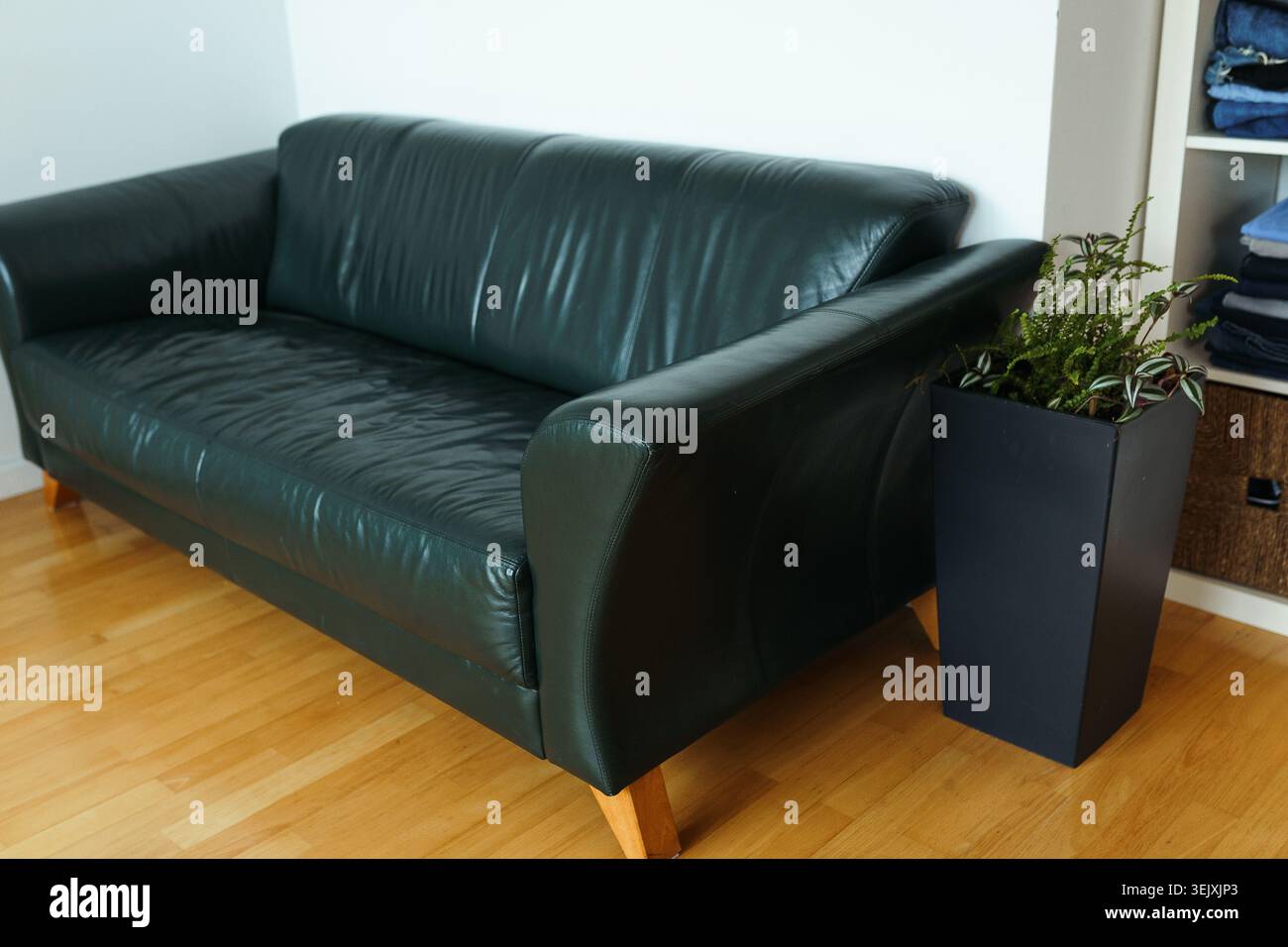 Retro-Ledersofa in Zimmer mit Parkettboden Stockfoto