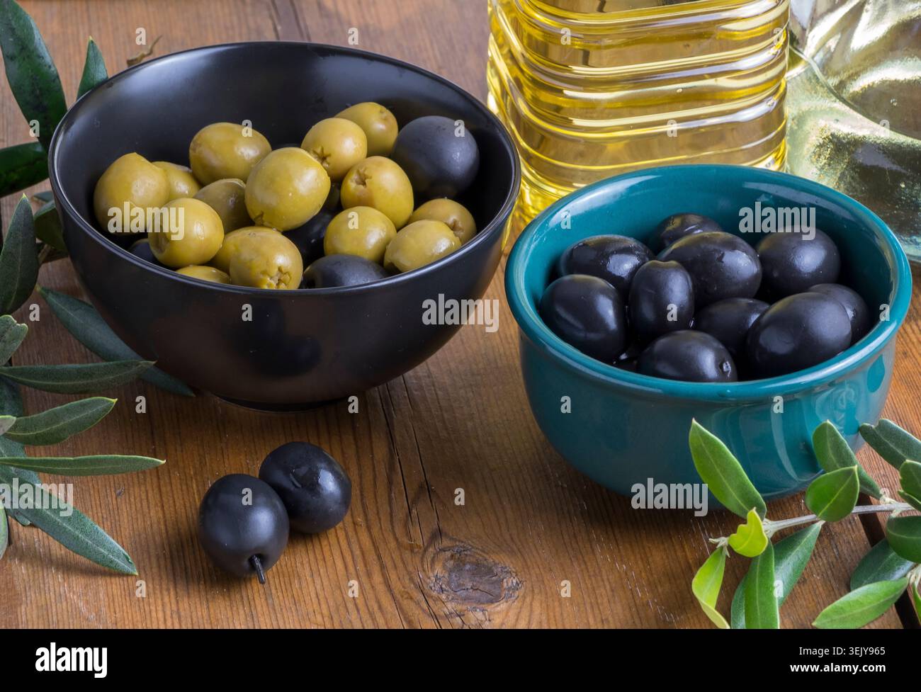 Oliven und Öl auf einem rustikalen Tisch Stockfoto