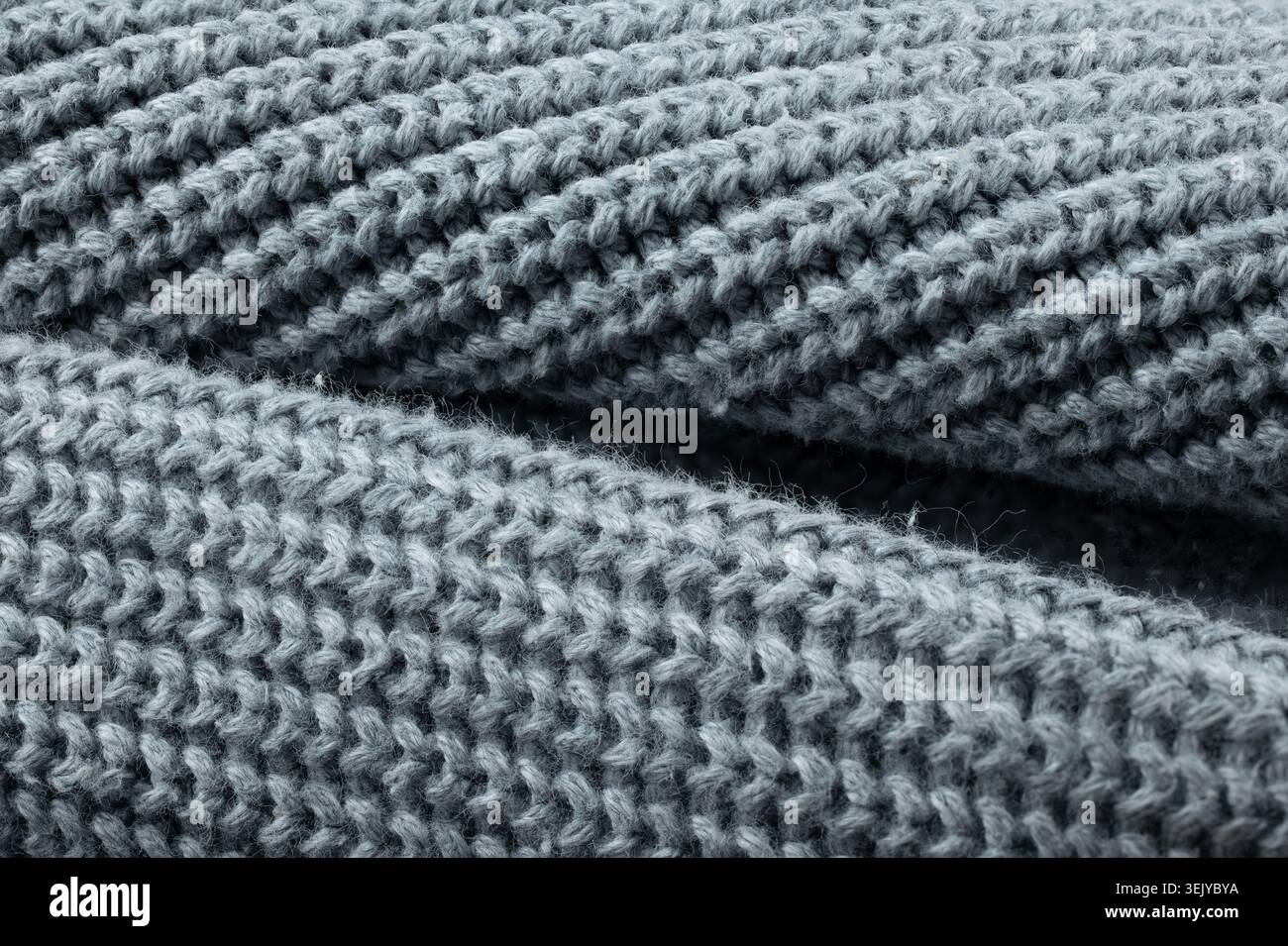 Detaillierte Textur aus weichem, grauem, geripptem Wollgewebe mit weicher Studiobeleuchtung Stockfoto