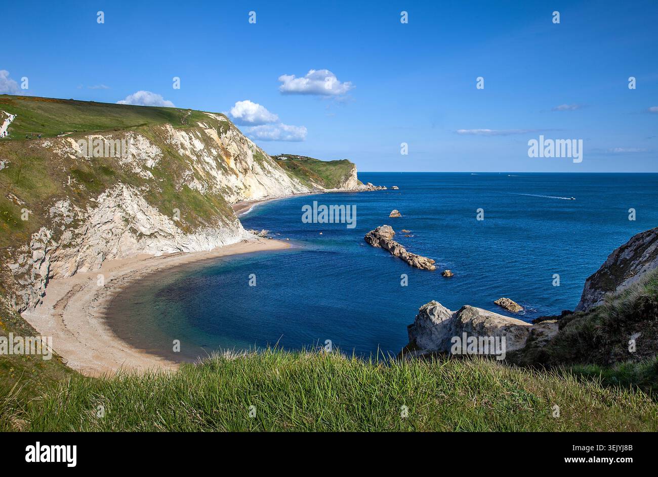 Dorset Coast, Großbritannien – man-o’ war Rocks und der berühmte Durdle Türbogen dahinter, eingerahmt von Kreidefelsen und dem klaren Wasser der Jurassic Coast. Stockfoto