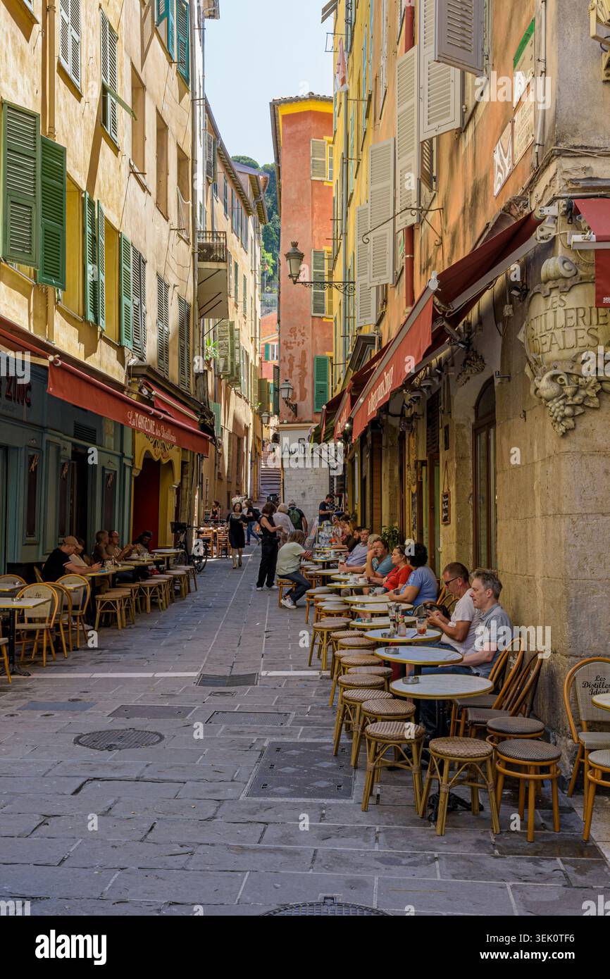 Die Menschen sitzen in Cafés in den engen Gassen von Vieux Nice, Nizza, Provence-Alpes-Côte d'Azur, Alpes-Maritimes, Frankreich Stockfoto