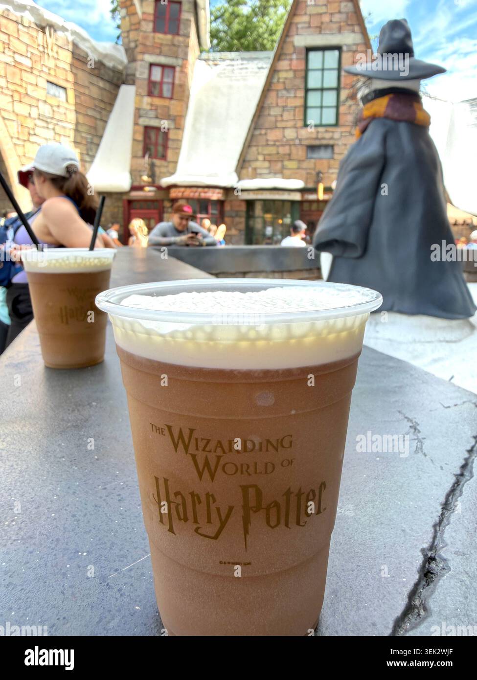 Bildunterschrift (139 Zeichen) ORLANDO, FL - 31. MAI 2026: Nahaufnahme eines kalten Butterbiergetränks in einem Souvenirbecher im The Wizarding World of Harry Pott - Smartphone-aufgenommenes Stockfoto
