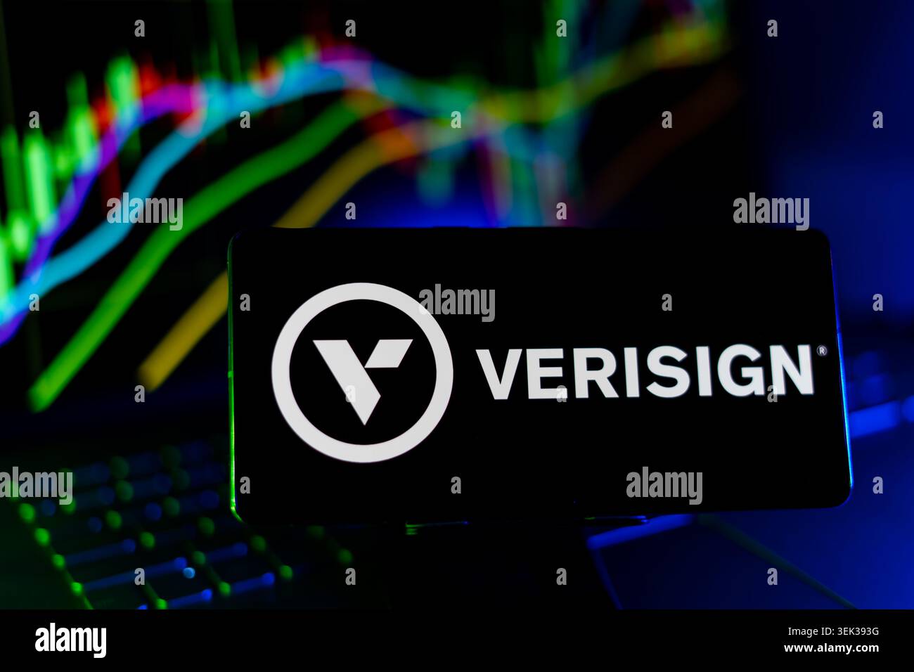 Verisign-Logo Wird Auf Dem Mobiltelefon Mit Hintergrund Des Aktienmarkt-Performance-Diagramms Und Schnittstelle Für Handelsdiagramme Angezeigt Stockfoto