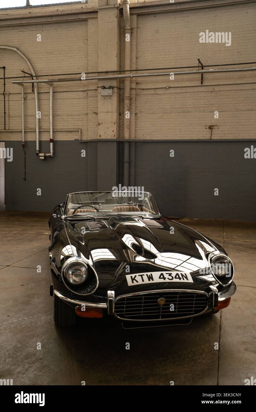 Der schwarze Jaguar E-Type Series 3 V12 Roadster KTW 434N parkte auf der Bicester Show in einem Industriegebäude Stockfoto