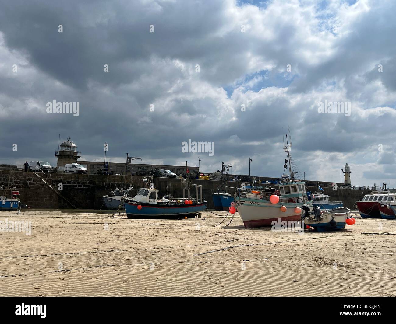 Boote am Harbour Beach mit Smeaton's Pier im Hintergrund in St Ives, Cornwall, England, UK. - Smartphone-aufgenommenes Stockfoto