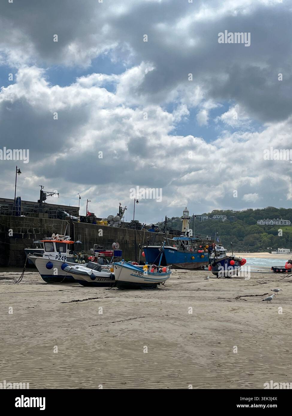Boote am Harbour Beach mit Blick auf den Leuchtturm in St Ives, Cornwall, England, UK. - Smartphone-aufgenommenes Stockfoto