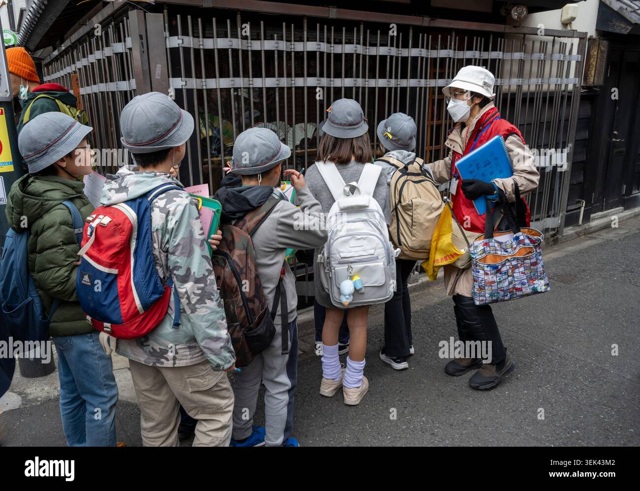 Schulkinder mit einem Lehrer auf der Straße in Tokio Stockfoto