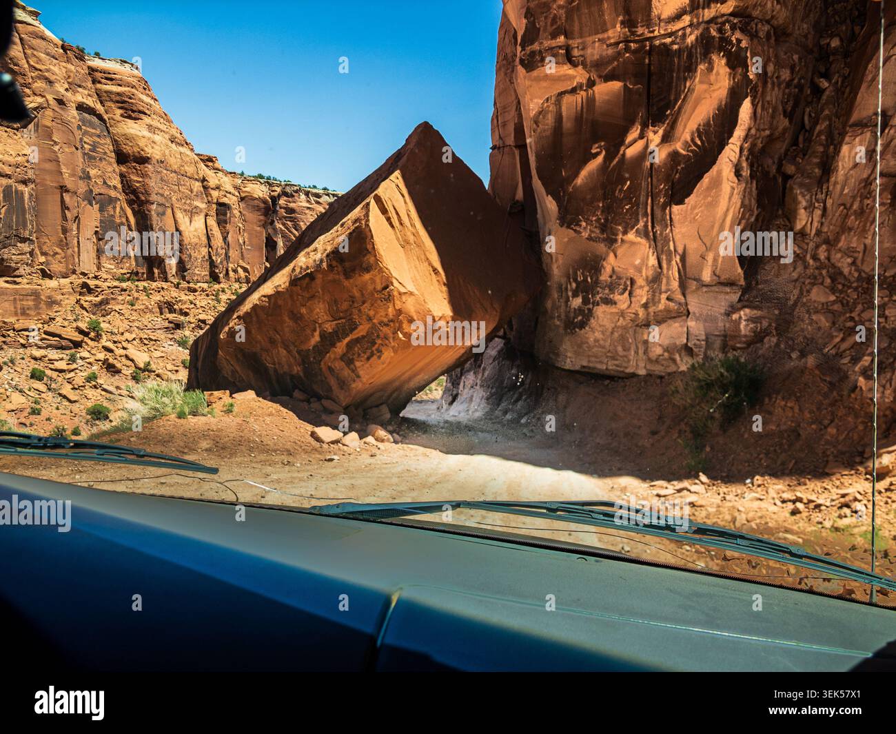 Ein riesiger Felsbrocken in den Moab Canyonlands blockiert die unbefestigte Straße bis auf kleine Fahrzeuge Stockfoto
