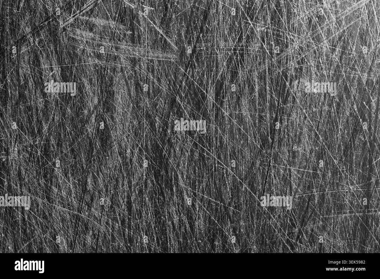 Chaotische Kratzstruktur auf der Metalloberfläche bietet einen dunklen abstrakten Grunge-Hintergrund mit beschädigten Details, die an raue, schwere industrielle Haptik erinnern Stockfoto
