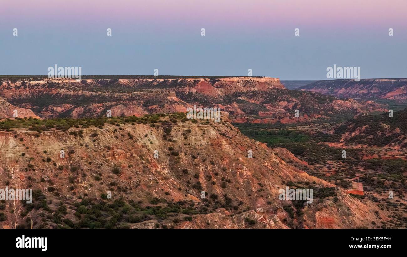 Der Palo Duro Canyon überblickt den Sonnenuntergang im Texas Panhandle und zeigt bunte Canyonkämme, rote Felsformationen und den Abendhimmel. Stockfoto