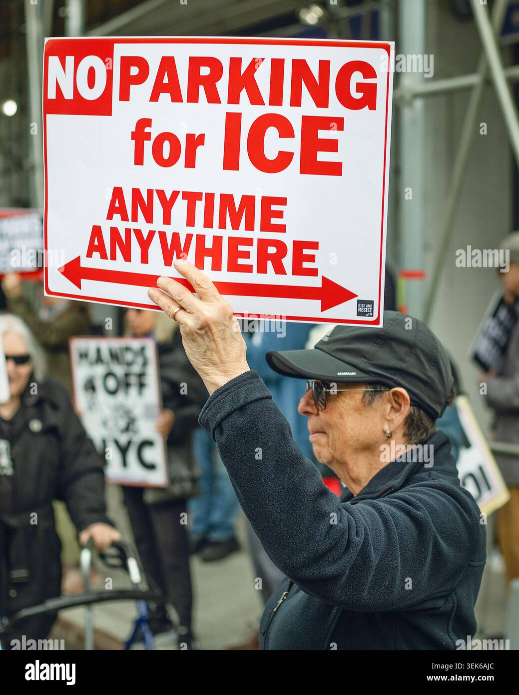 Eine ältere Frau hält ein Anti-EIS-Protestzeichen Stockfoto