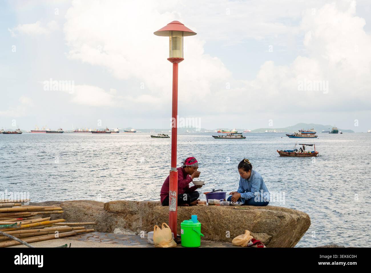 Koh Loy, Thailand. 31. Mai 2026. Ein Paar beim Essen auf einem großen Felsen am Meer auf Koh Loy Island. Wat Koh Loy (Sri Maharacha Tempel) steht auf dem höchsten Punkt von Koh Loy, einer kleinen Insel 500 Meter vor der Küste von Si Racha, Chon Buri, die mit dem Festland durch eine Brücke verbunden ist. Quelle: SOPA Images Limited/Alamy Live News Stockfoto