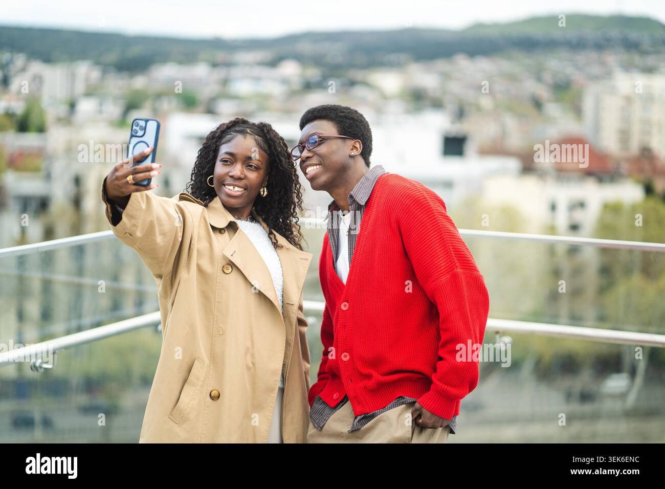 Glückliche afroamerikanische verheiratete Paare posieren an einem hohen Aussichtspunkt in der Stadt und machen Selfie auf dem Smartphone, lächelnde schwarze männliche und weibliche Partner, die Touristen zusammen auf dem Handy fotografieren. Stockfoto