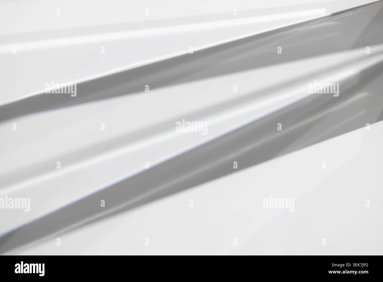 Abstraktes Licht und Schatten auf geometrischer Metallic-Oberfläche in minimalistischem Design Stockfoto