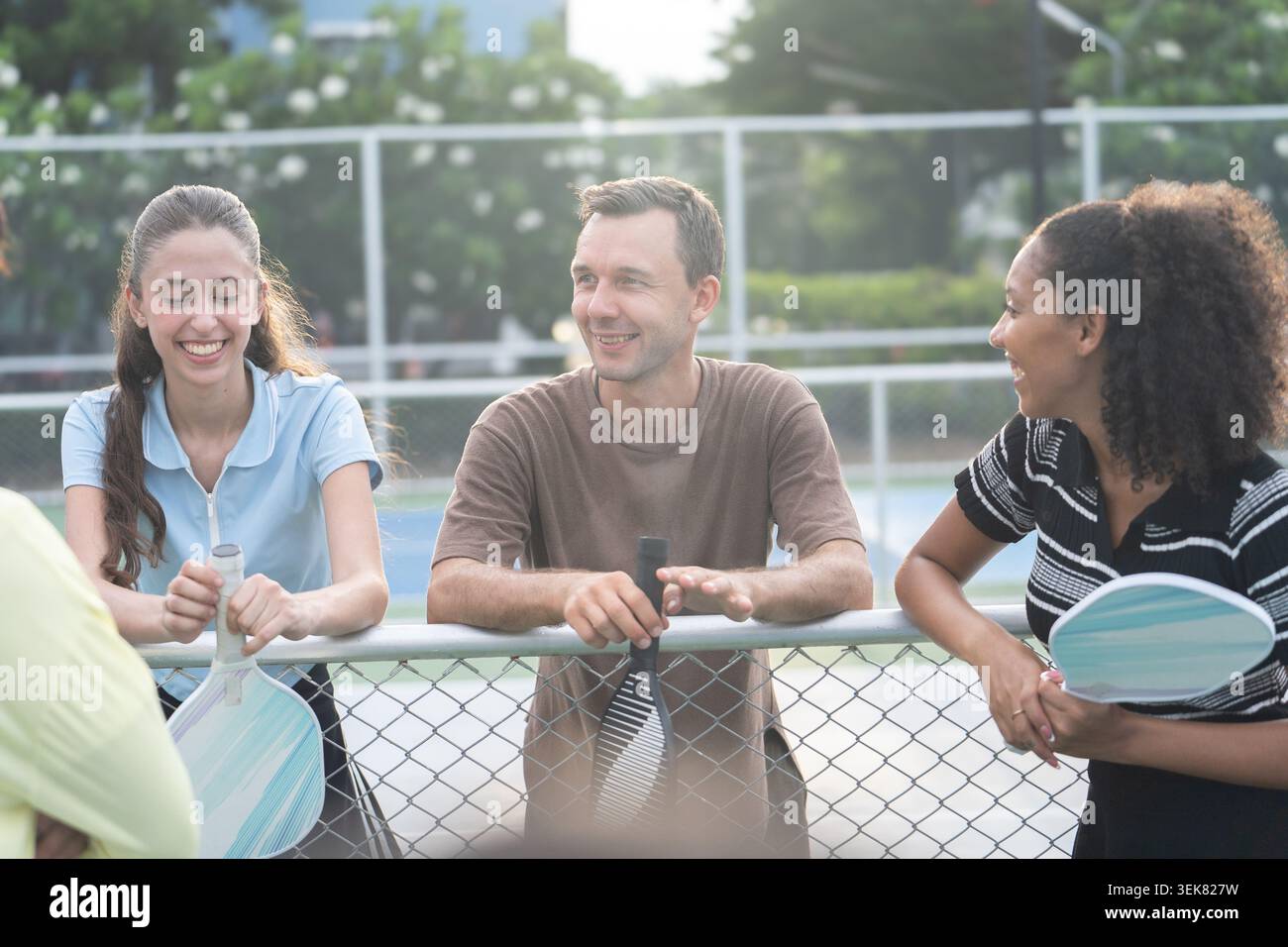 Aktive, vielfältige Leute spielen Pickleball auf dem Outdoor Court Stockfoto