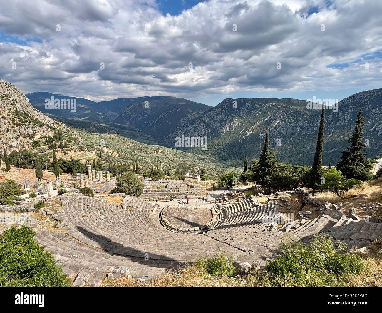 Das antike Theater von Delphi, Griechenland, mit Blick auf das Heiligtum und die Hänge des Parnassos unter dramatischen Wolken. Stockfoto