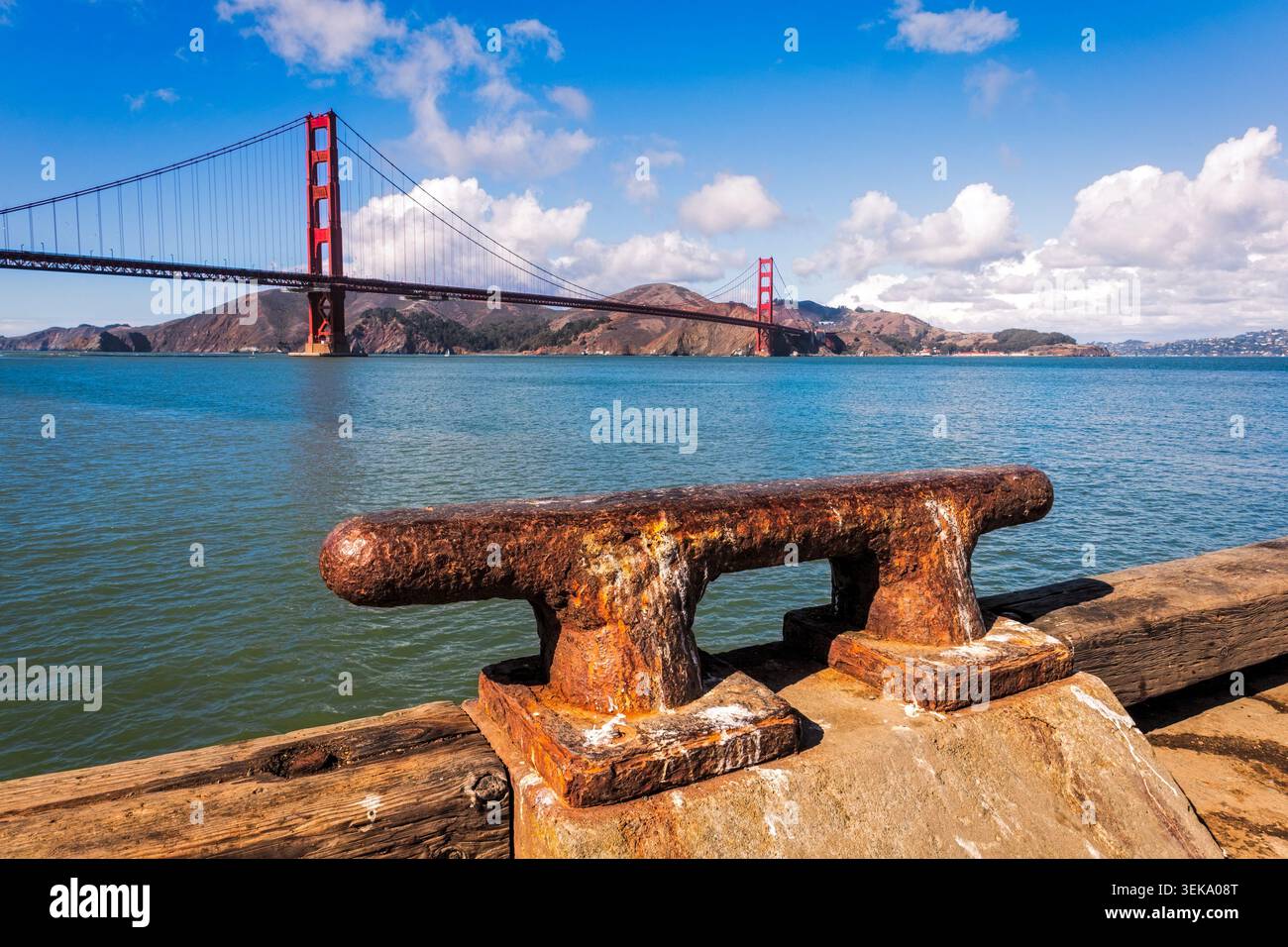 Rostiger Schiffspoller auf einem hölzernen Pier mit der berühmten Golden Gate Bridge, die die Bucht überquert Stockfoto