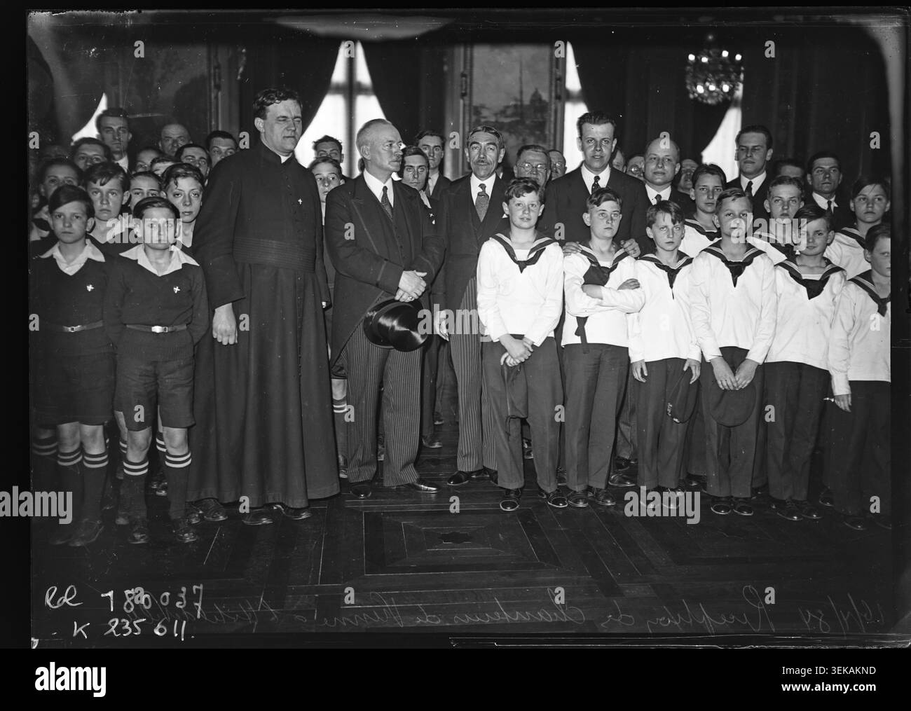 René Fiquet nimmt am 16. April 1934 an einem Empfang für Sängerinnen und Sänger aus Wien im Pariser Rathaus Teil. Das Pressefoto zeigt die kleinen Sänger am Holzkreuz, österreichische Kinderchöre, französische Kinderchöre und Gemeinderäte. Stockfoto
