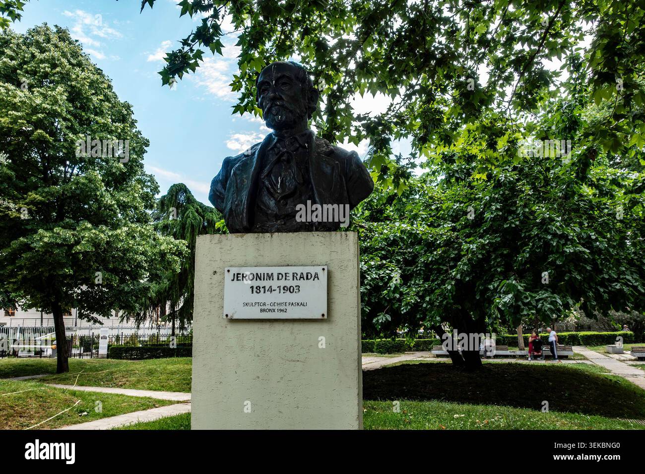 Die Büste Jeronim de Rada in Tirana, Albanien, steht auf einem Steinsockel mit Namensschild in einem grünen öffentlichen Park, umgeben von üppigen Bäumen. Stockfoto