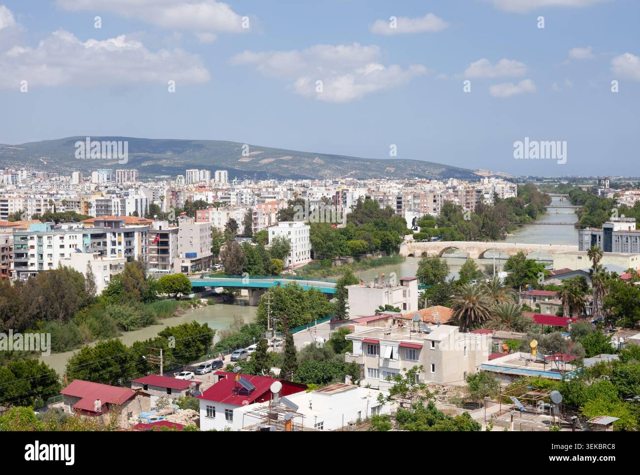 Eine erhöhte Ansicht zeigt die dichte urbane Stadt Silifke, die vom breiten Göksu-Fluss geteilt wird. Stockfoto