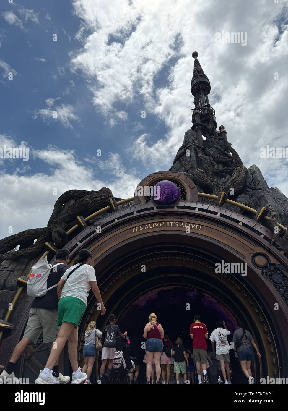 ORLANDO, FL - 1. JUNI 2026: Touristen spazieren unter dem „IT's Alive!“ Eingang zum Dark Universe Portal am Epic Universe des Universal Orlando Resorts. - Smartphone-aufgenommenes Stockfoto