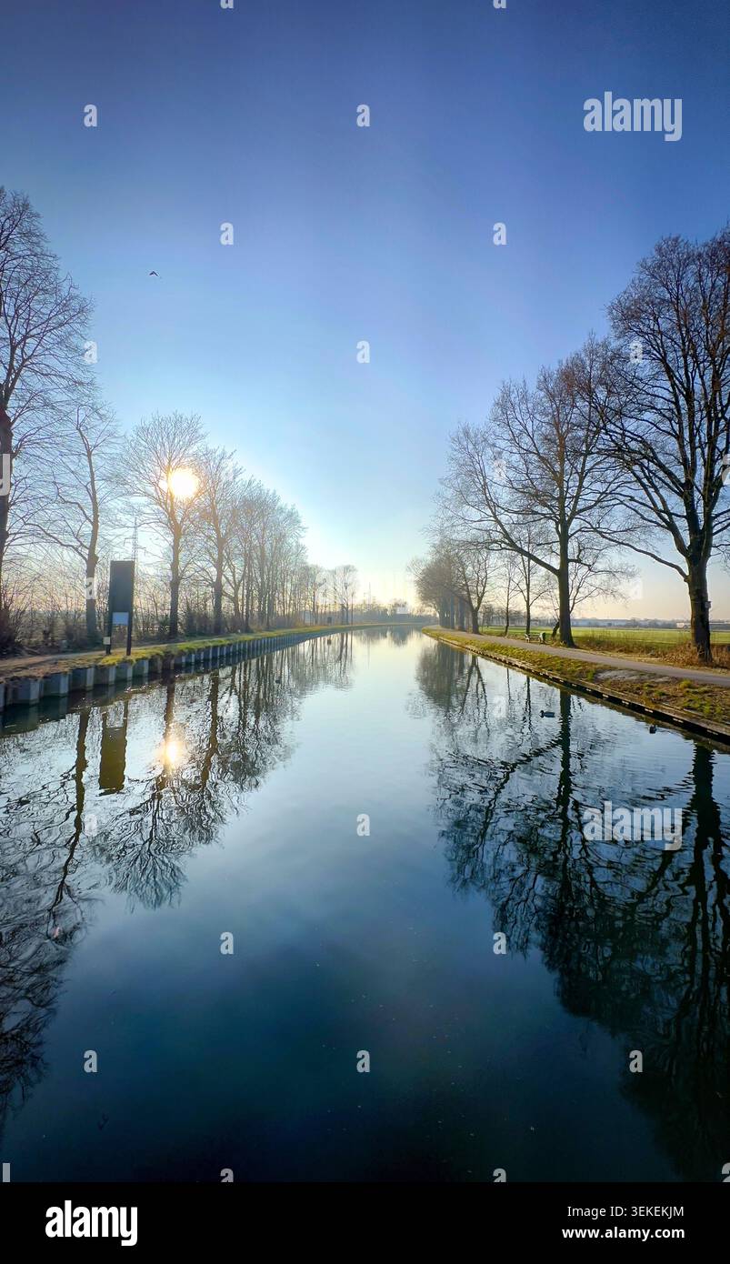 Ein ruhiger Blick auf einen fließenden Fluss, der Bäume und den Himmel reflektiert und den Charme der Natur einfängt Stockfoto