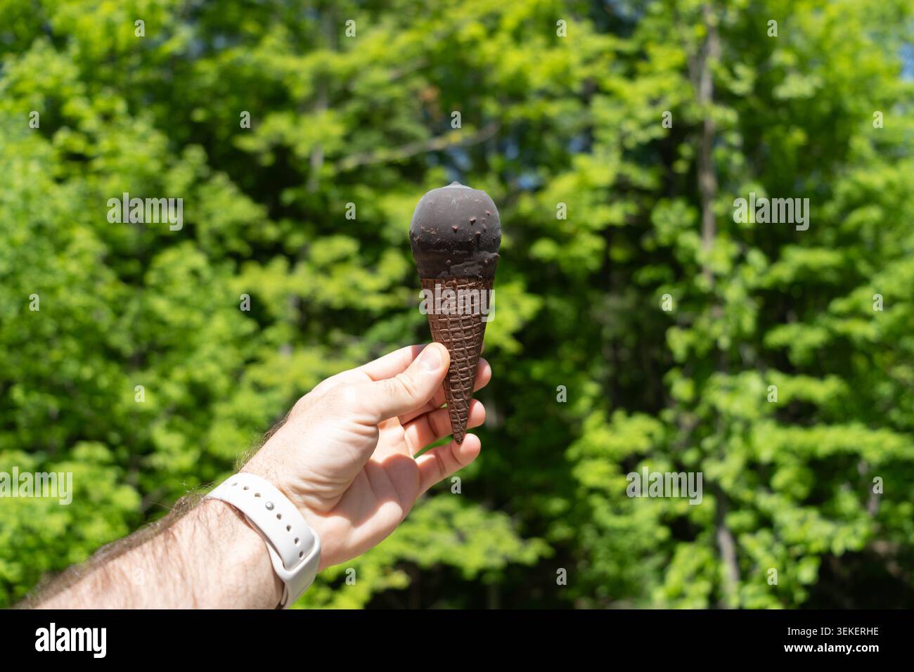 Hand Hält In Schokolade Getauchten Eiskegel Im Freien Stockfoto