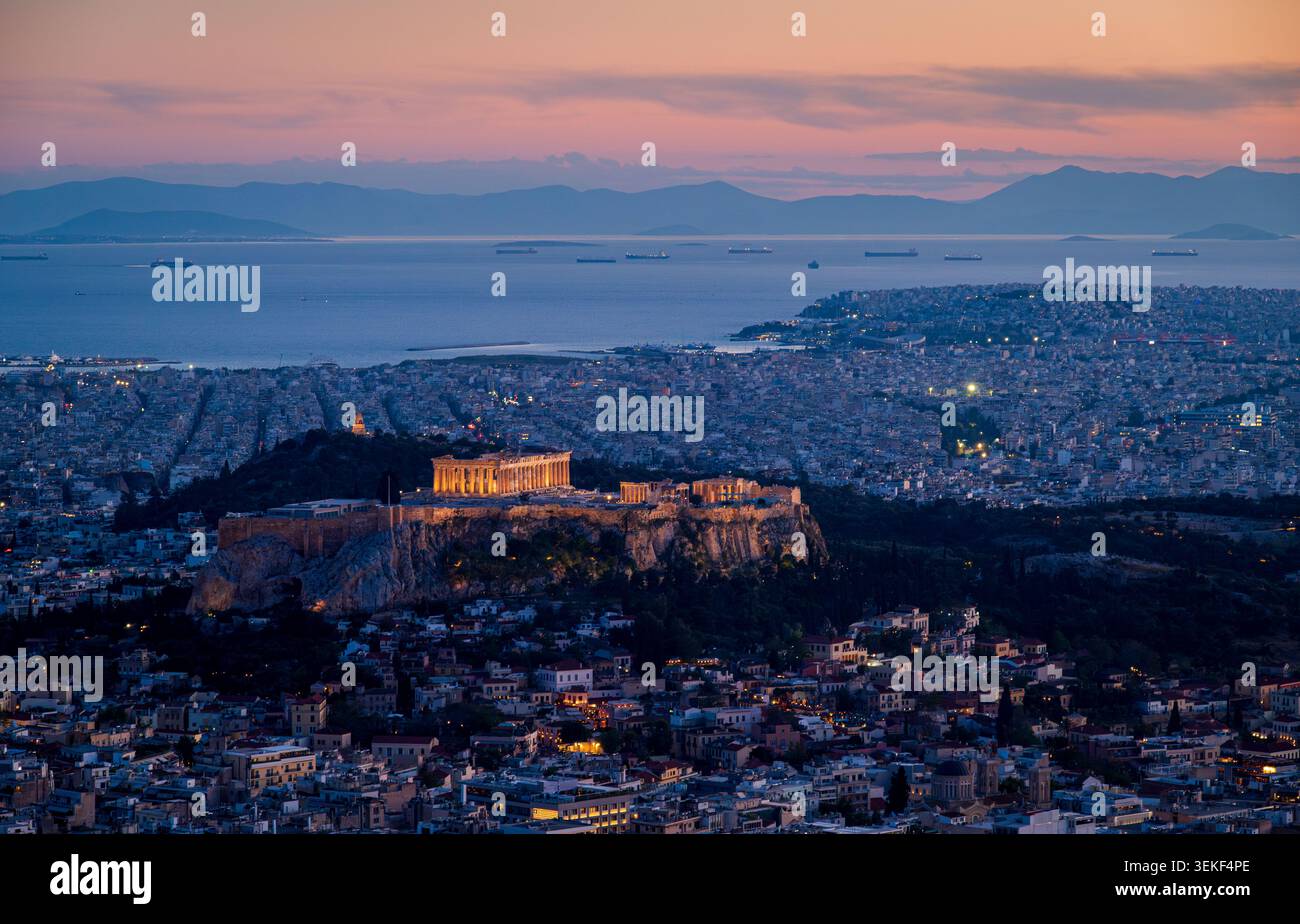Tele-Blick vom Lycabettus-Hügel mit Blick auf die beleuchtete Akropolis nach Sonnenuntergang mit der Skyline von Athen und den Saronischen Golf Stockfoto