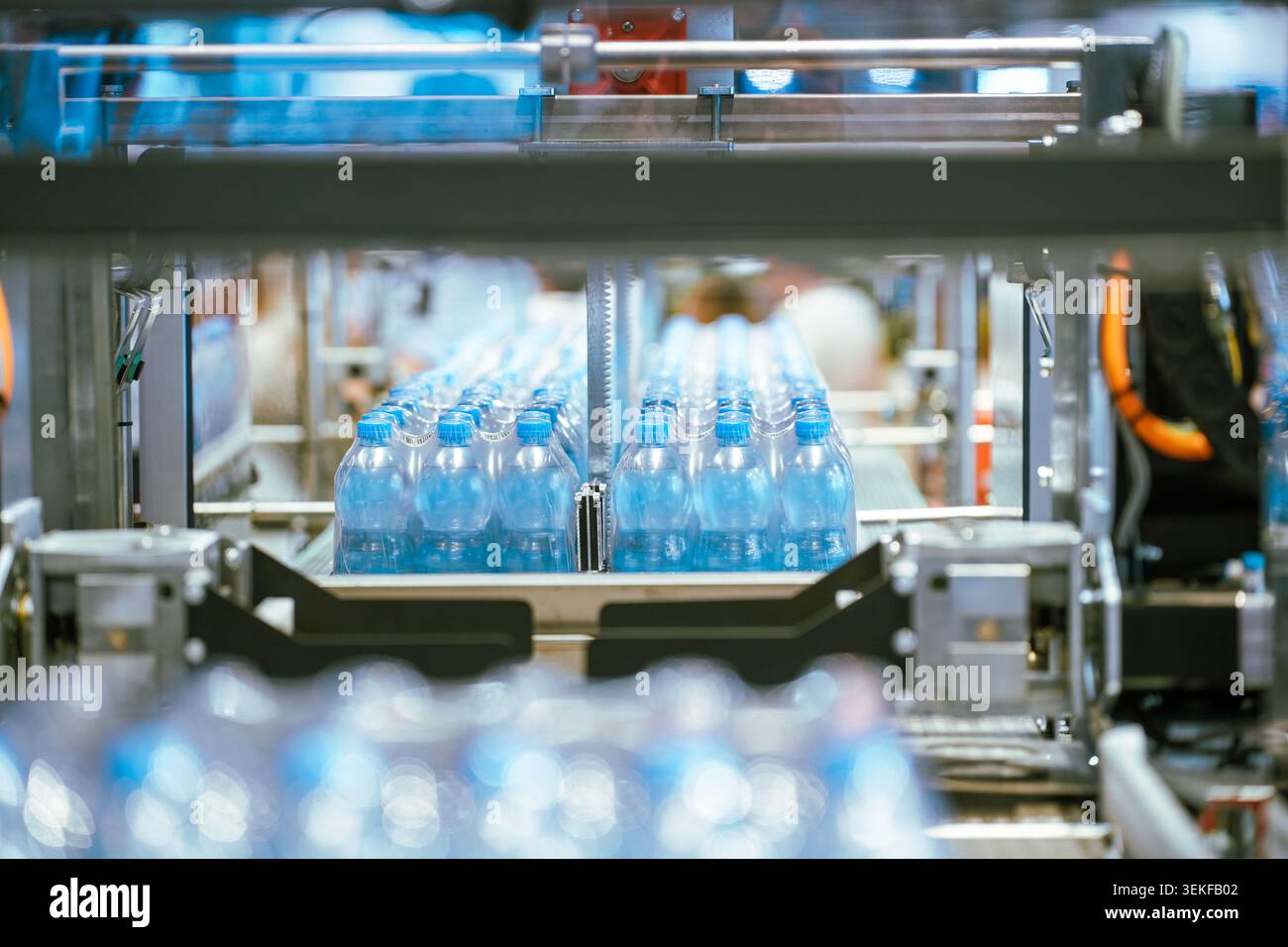 Bei einer Verpackungsvorführung auf einer Messe für industrielle Fertigung bewegen sich Verpackungen mit Kunststoffflaschen entlang eines automatisierten Förderbandsystems Stockfoto