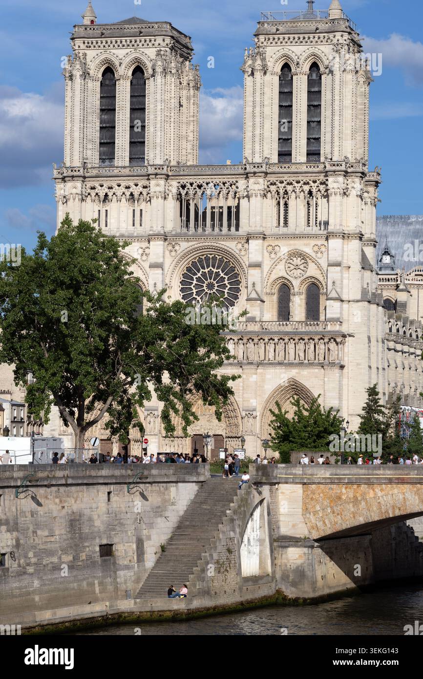 Die Kathedrale Notre-Dame erhebt sich über die seine und die Stufen am Flussufer in Paris. Stockfoto