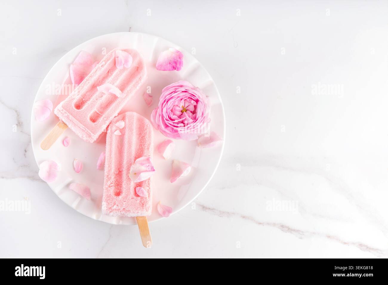 Süße Kräuterrose Eis Lollies in Sticks, leckerer cremiger Tee Rose Blumen gefrorenes Dessert mit Rosenknospen auf weißem Marmor Tisch Backgr Stockfoto