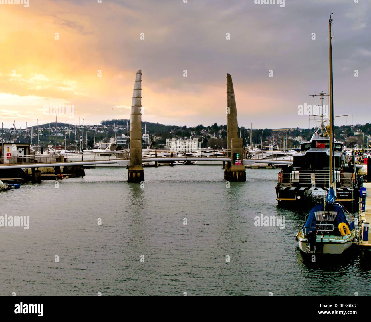 Sonnenuntergang über der Fußgängerbrücke des Hafens/Yachthafens und dem Boot cill Torquay. Stockfoto