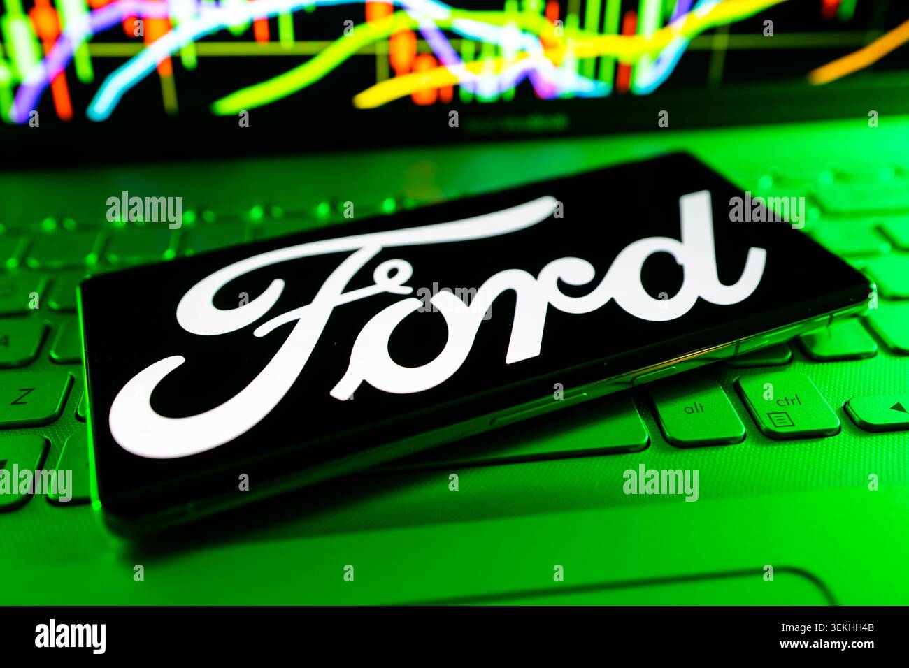 Das Firmenlogo Der Ford Motor Company Wird Auf Dem Mobilen Bildschirm Mit Dem Hintergrund Des Finanzdiagramms Angezeigt Stockfoto