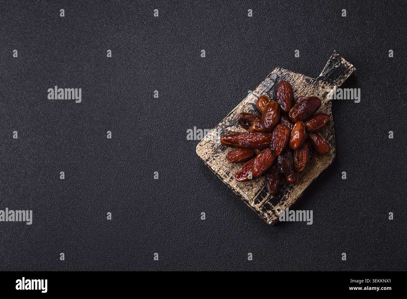 Getrocknete Datteln auf einer Keramikplatte, arabisches Essen für den ramadan-Tisch. Getrocknete Datteln als kulinarische Kulisse für Ihr Design Stockfoto