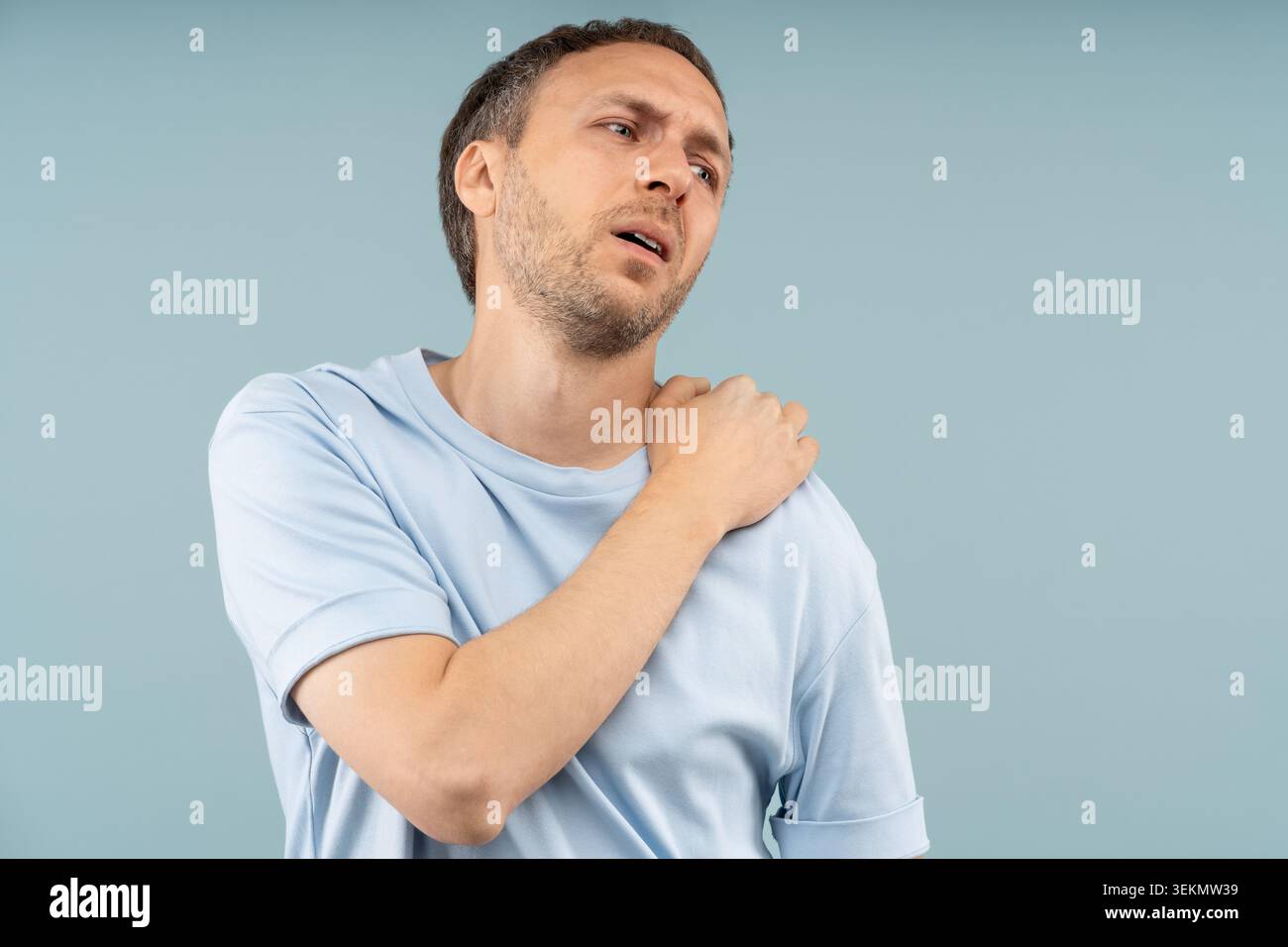 Wenden bei Schmerzen Mann mit scharfen Schulterschmerzen eingeschränkte Mobilität, leidet an Problemen mit der Halswirbelsäule, Bandscheibenvorfall, Nervenkompression fühlt sich unangenehm an Stockfoto