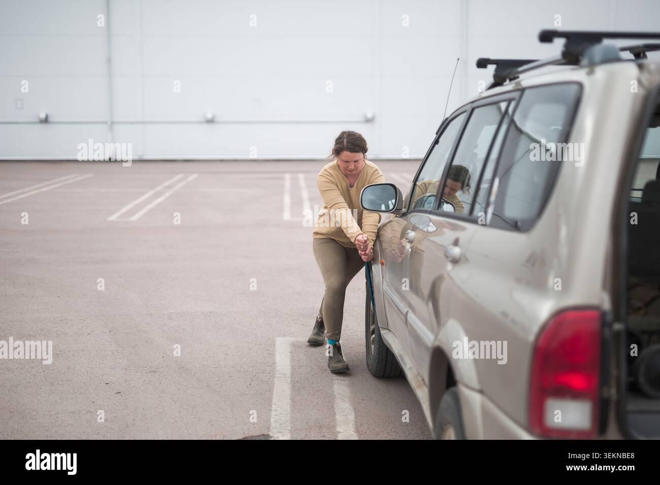 Die volle Länge des weiblichen Radschraubers beim Reifenwechsel des Autos Stockfoto