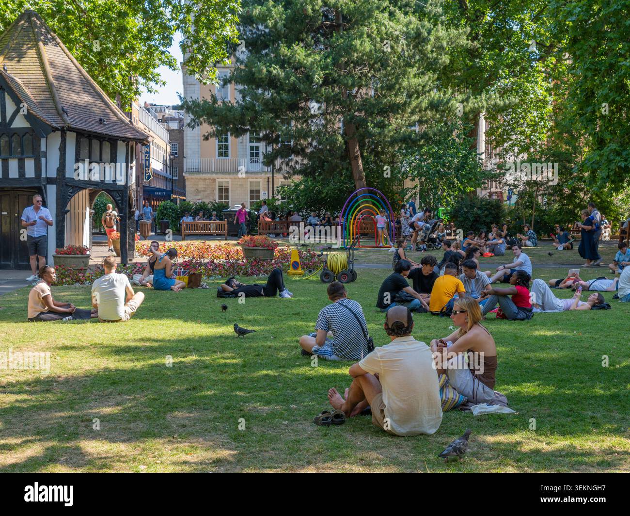 London, Vereinigtes Königreich - 11. Juli 2025: Menschenmassen verschiedener Menschen, die sich auf üppigem Parkgras in london erhitzen und sich dort mit Freunden unterhalten Stockfoto