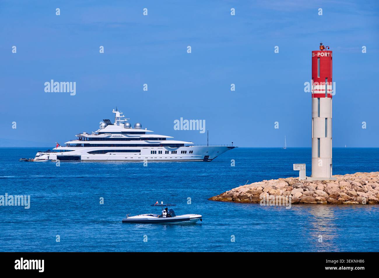 Luxus-Superyacht AMADEA in Anchor nahe Harbour Breakwater und Red Navigation Beacon am sonnigen Tag Stockfoto