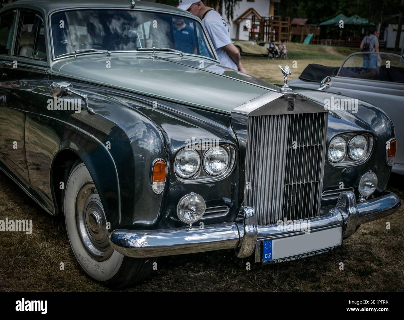 Auf der Vorderseite befindet sich ein Foto einer luxuriösen Limousine von Rolls-Royce, die die legendäre Anordnung von Kühlergrill und Scheinwerfern unterstreicht. Stockfoto