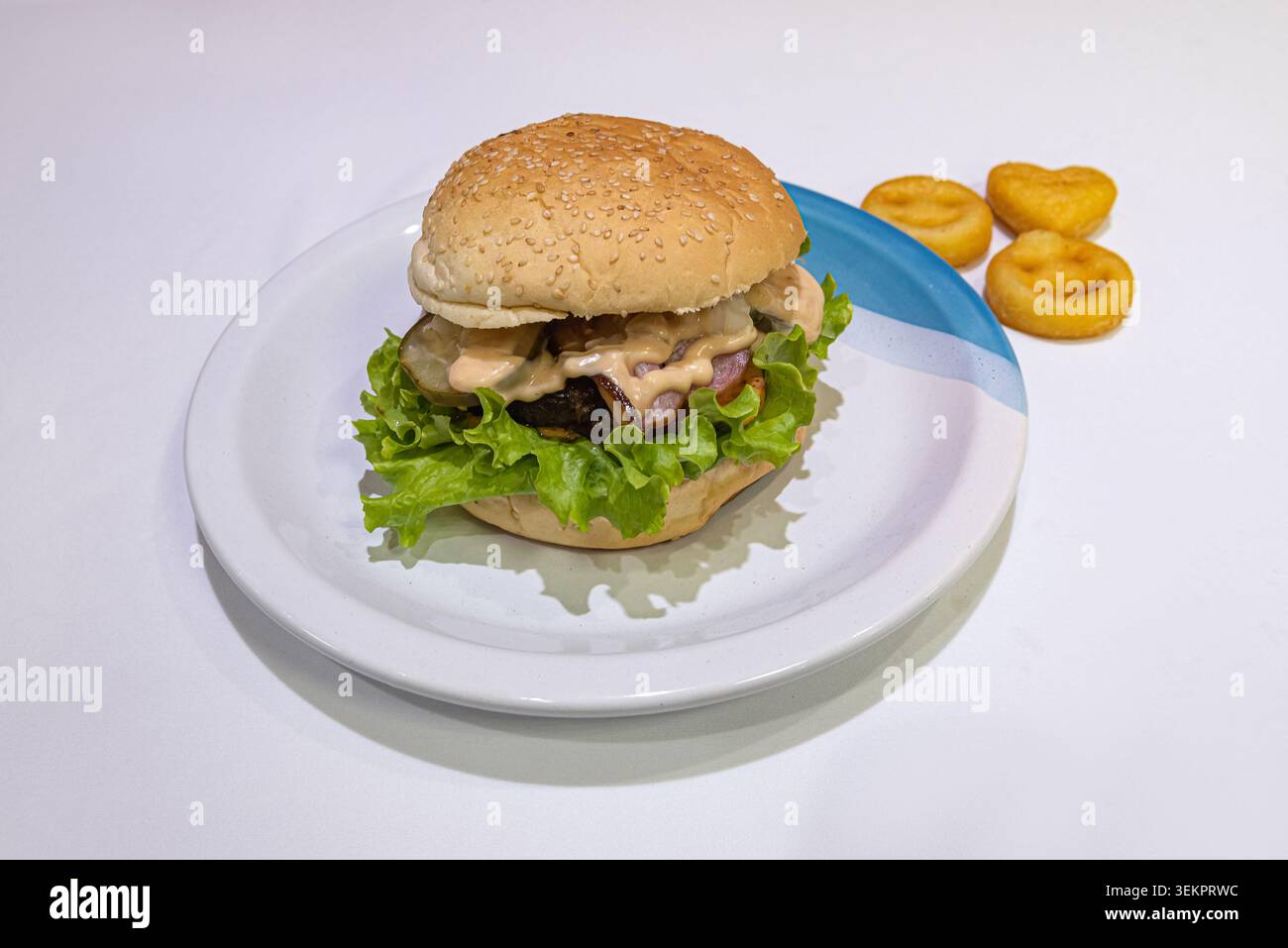 Burger mit frischem Salat, Veggie Patty und Kartoffellächeln auf weiß. Aufnahme mit neutraler Beleuchtung, zeigt gesunde Optionen. Perfekt gesund e Stockfoto