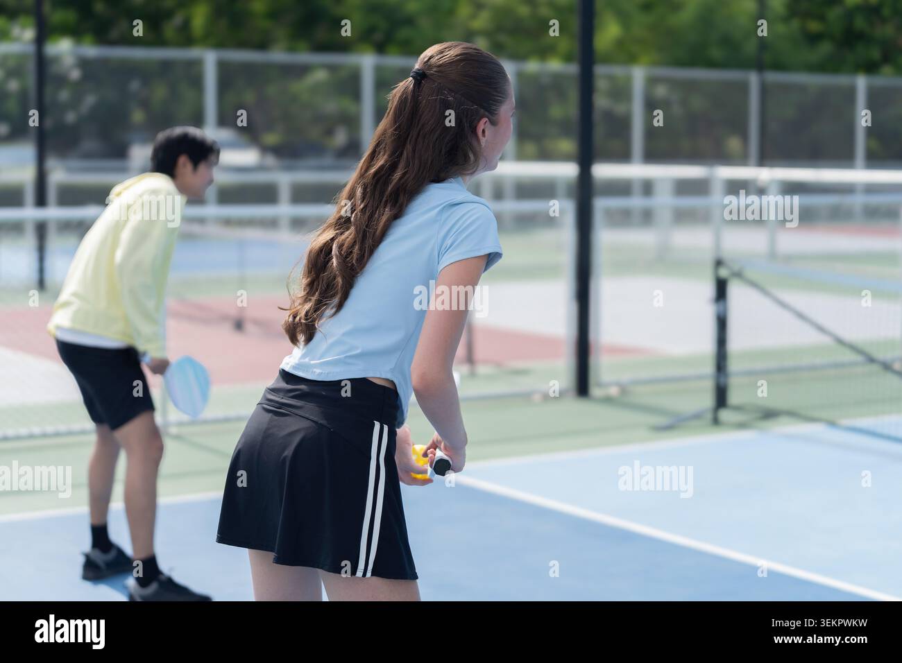 Junge Kaukasische Frau, Die Draußen Pickleball Spielt Stockfoto