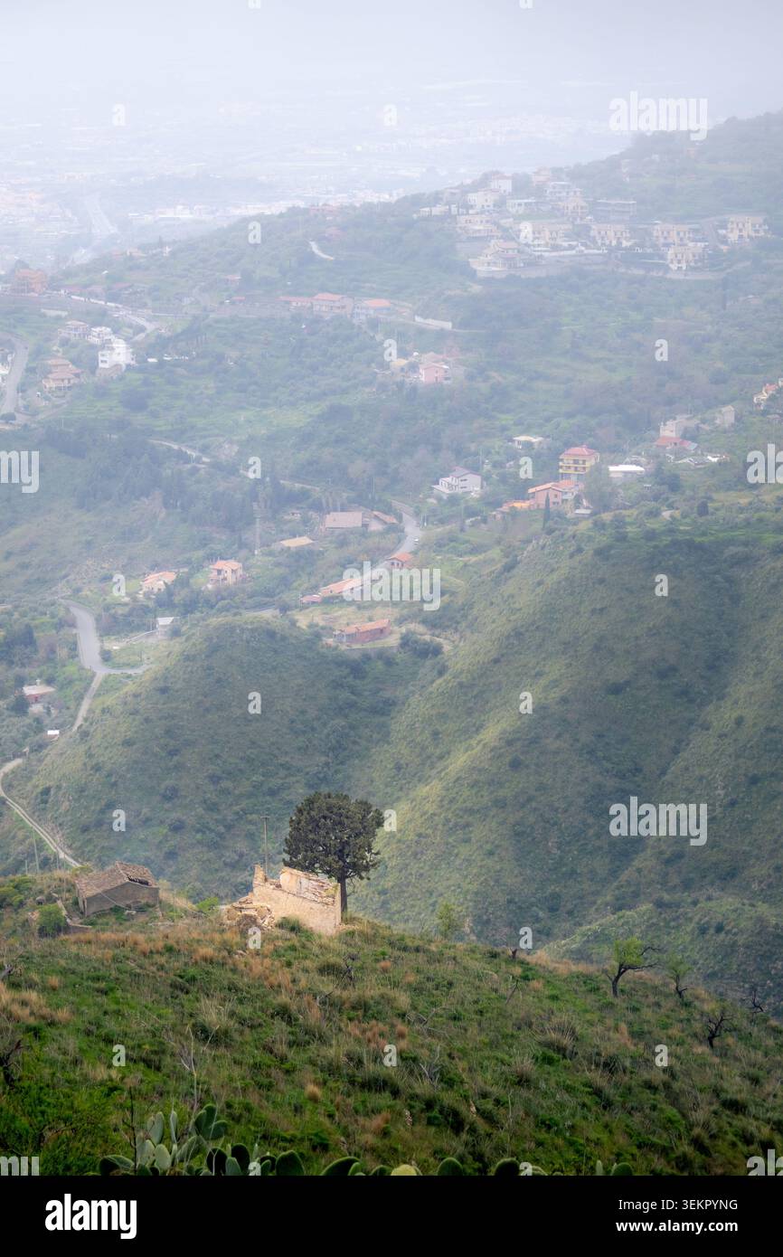 Malerischer Bergweg Taormina - Castelmola mit Kaktuspflanzen und bergiger Ppe, Sizilien. Nebeliges Wetter erzeugt eine ruhige Stimmung, ein Konzept von Einsamkeit, Stockfoto