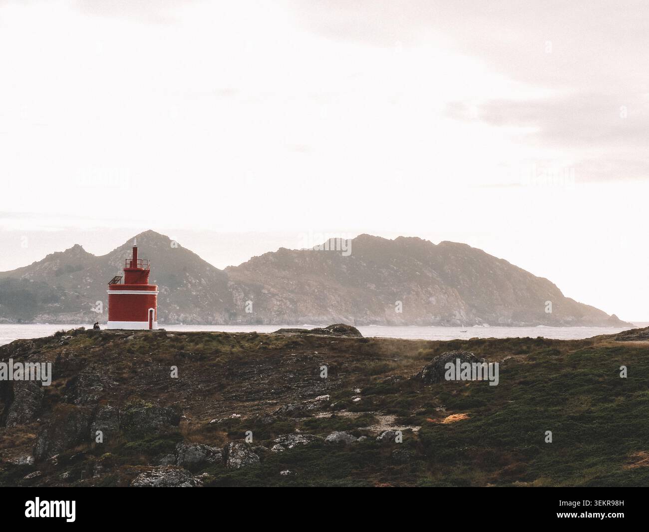 Der berühmte leuchtend rote Punta Robaleira Leuchtturm auf den zerklüfteten Felswänden von Costa da Vela, Cangas, Galicien, Spanien. Atlantik Stockfoto