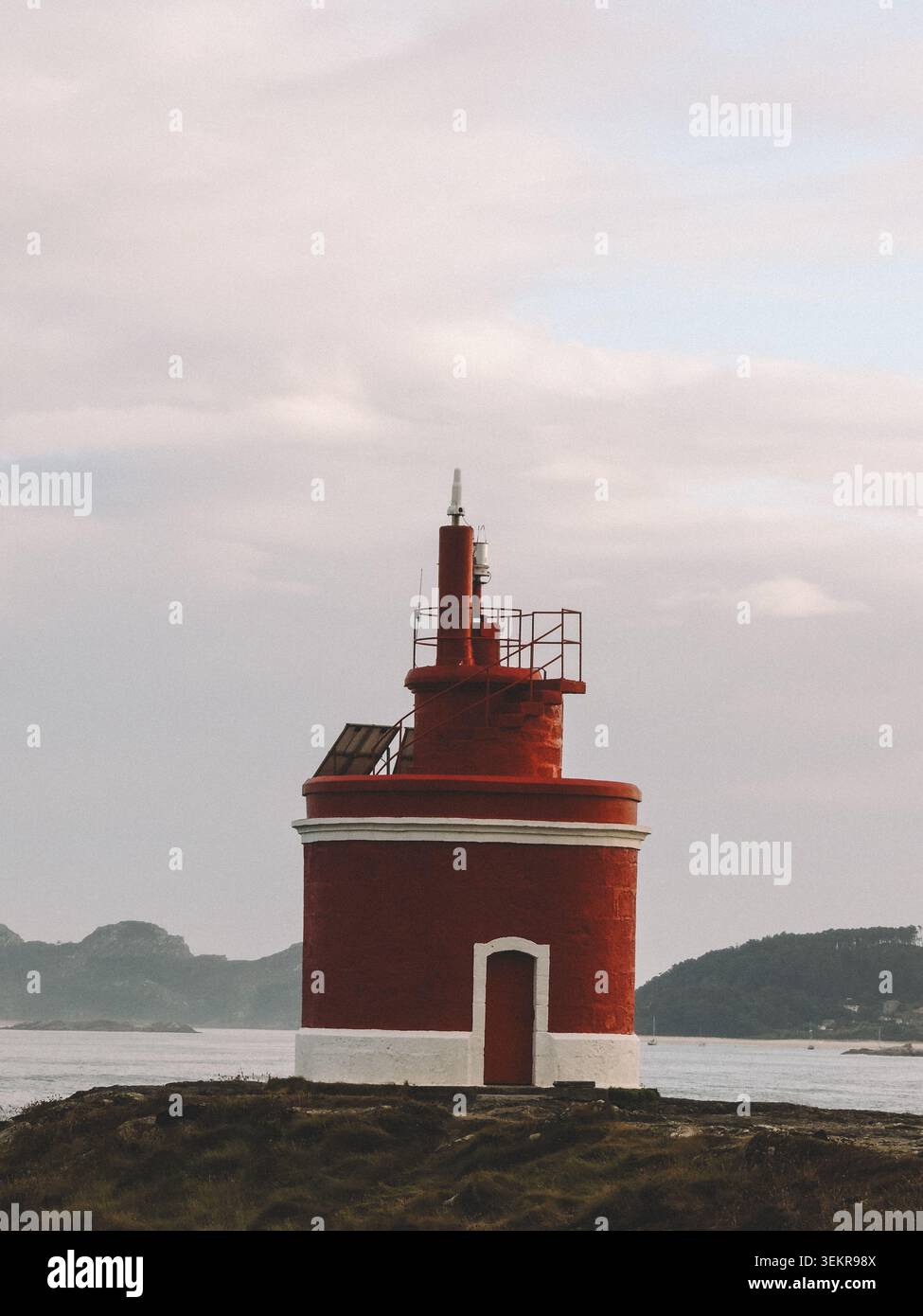 Der berühmte leuchtend rote Punta Robaleira Leuchtturm auf den zerklüfteten Felswänden von Costa da Vela, Cangas, Galicien, Spanien. Atlantik Stockfoto