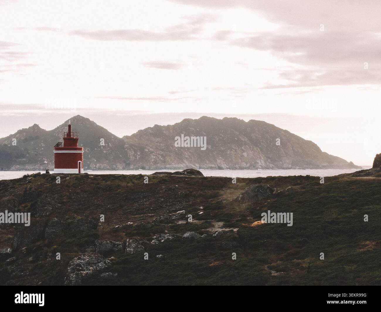 Der berühmte leuchtend rote Punta Robaleira Leuchtturm auf den zerklüfteten Felswänden von Costa da Vela, Cangas, Galicien, Spanien. Atlantik Stockfoto