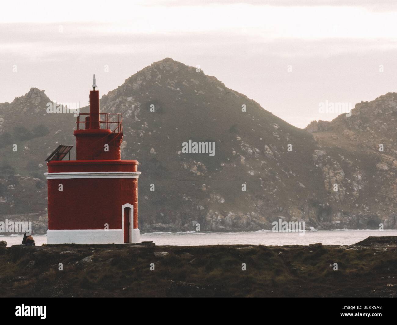 Der berühmte leuchtend rote Punta Robaleira Leuchtturm auf den zerklüfteten Felswänden von Costa da Vela, Cangas, Galicien, Spanien. Atlantik Stockfoto