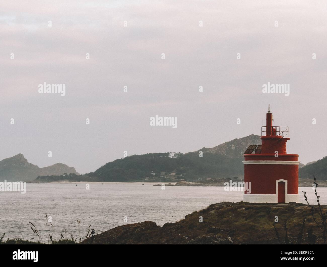 Der berühmte leuchtend rote Punta Robaleira Leuchtturm auf den zerklüfteten Felswänden von Costa da Vela, Cangas, Galicien, Spanien. Atlantik Stockfoto
